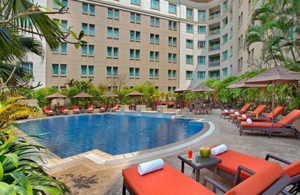 Pool view at PARKROYAL Yangon Hotel, a gay-friendly hotel in Yangon. Loungers, umbrellas, and drinks by the pool for a relaxing stay.