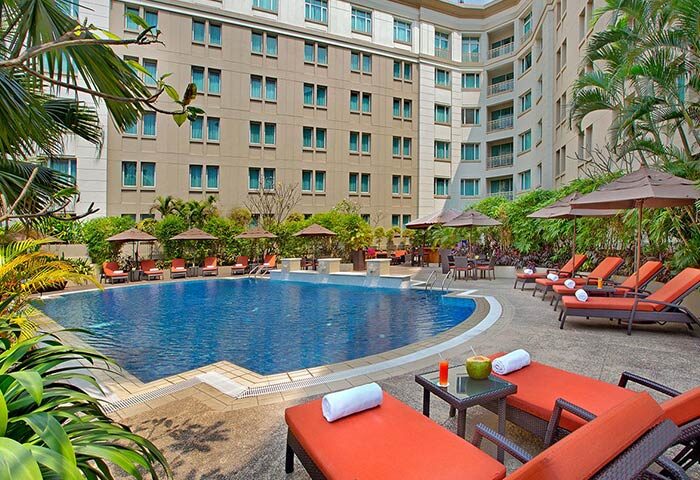 Pool view at PARKROYAL Yangon Hotel, a gay-friendly hotel in Yangon. Loungers, umbrellas, and drinks by the pool for a relaxing stay.