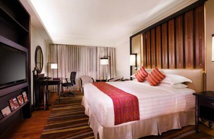 PARKROYAL Yangon Hotel room. Gay-friendly hotel with a bed, desk, TV, and striped rug. Upscale accommodations for gay travelers in Yangon.