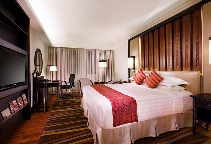 PARKROYAL Yangon Hotel room. Gay-friendly hotel with a bed, desk, TV, and striped rug. Upscale accommodations for gay travelers in Yangon.