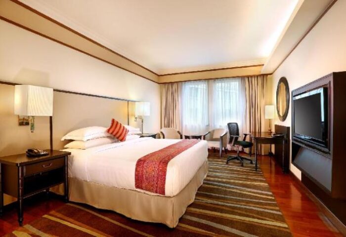 PARKROYAL Yangon Hotel room. Gay-friendly hotel with king bed, desk, TV, and seating area. Comfortable stay in Yangon, Myanmar.