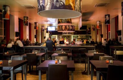 PLUS Berlin Hotel & Hostel's gay-friendly bar area. Stylish lighting fixtures and a relaxed atmosphere for gay travelers in Berlin.