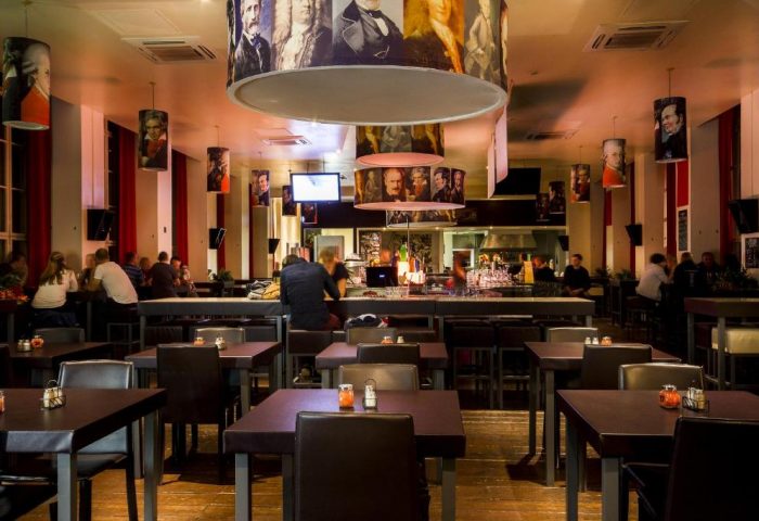 PLUS Berlin Hotel & Hostel's gay-friendly bar area. Stylish lighting fixtures and a relaxed atmosphere for gay travelers in Berlin.