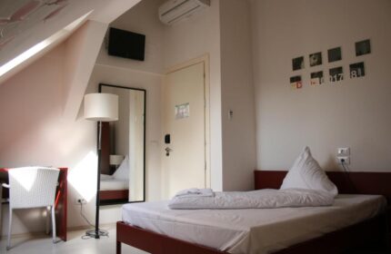 PLUS Berlin Hotel & Hostel room. Gay-friendly lodging with bed, desk, and modern decor. Ideal for gay travelers in Berlin.