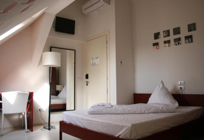 PLUS Berlin Hotel & Hostel room. Gay-friendly lodging with bed, desk, and modern decor. Ideal for gay travelers in Berlin.