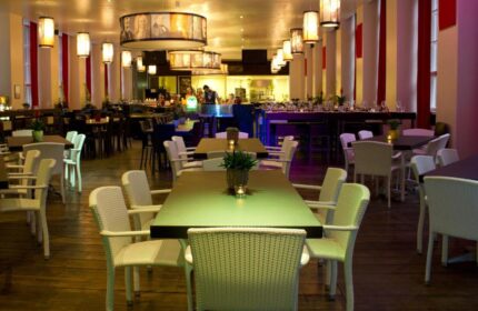 PLUS Berlin Hotel & Hostel's stylish restaurant. Tables and chairs fill the large room with unique lighting. Gay-friendly hotel in Berlin.