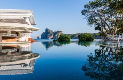 Infinity pool at gay-friendly PP Charlie Beach Resort. Tropical island view. Ideal for gay men's travel. Serene beach hotel, perfect getaway.