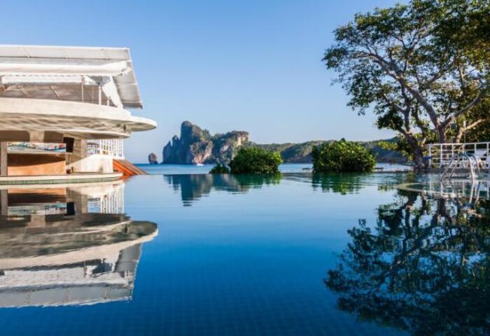 Infinity pool at gay-friendly PP Charlie Beach Resort. Tropical island view. Ideal for gay men's travel. Serene beach hotel, perfect getaway.