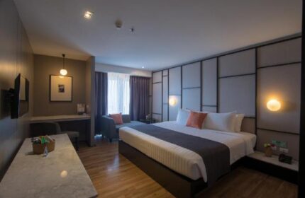 Page 10 Hotel's gay-friendly room: King bed with stylish headboard, desk, and seating area. Perfect for gay men travelers seeking comfort.