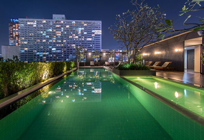 Page 10 Hotel rooftop pool at night. Gay-friendly hotel with city views. Relaxing travel destination for gay men. Modern design, luxury.