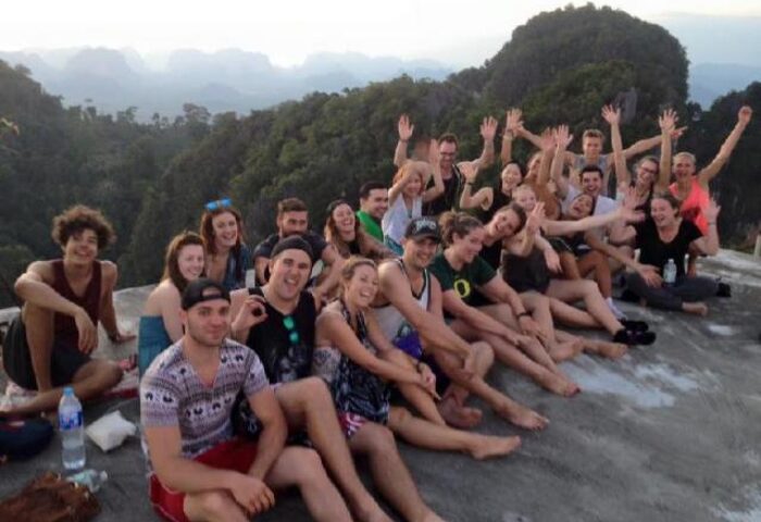 Group of travelers at Pak Up Hostel, a gay-friendly hotel. Guests are smiling, waving, and enjoying the view. A great spot for gay travel.