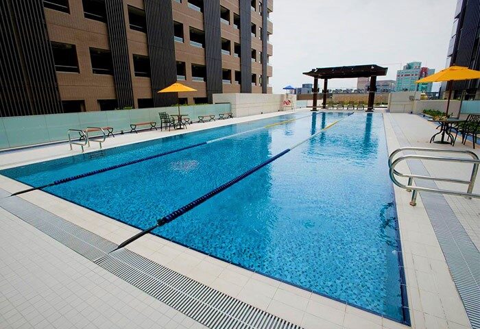 Palais de Chine Hotel's outdoor pool. Gay-friendly hotel with swimming lanes, umbrellas, and lounge area. Great for gay men travelers.