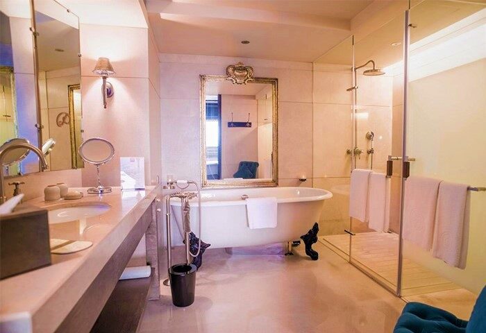Palais de Chine Hotel bathroom. Gay-friendly hotel with luxury bathtub, glass shower, and elegant design. Ideal for gay travel and relaxation.