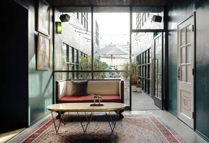 Palihotel Melrose lobby with seating area. Gay-friendly hotel with stylish interior design, courtyard view, and vintage rug. Great for gay travel.