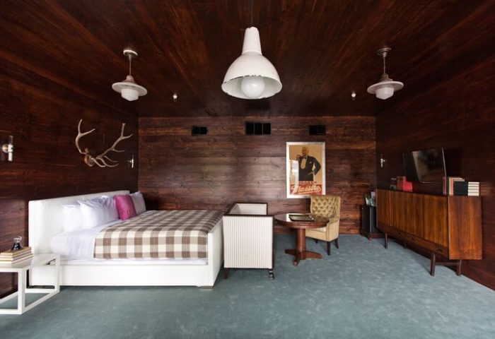 Palihotel Melrose room. Gay-friendly hotel with dark wood paneling, plaid bedspread, vintage furniture, & stag antlers. Stylish, unique design.