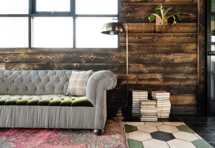 Palihotel Melrose interior. Stylish gay-friendly hotel with striped couch, wood paneling, and unique decor. Ideal for gay travel in Melrose.