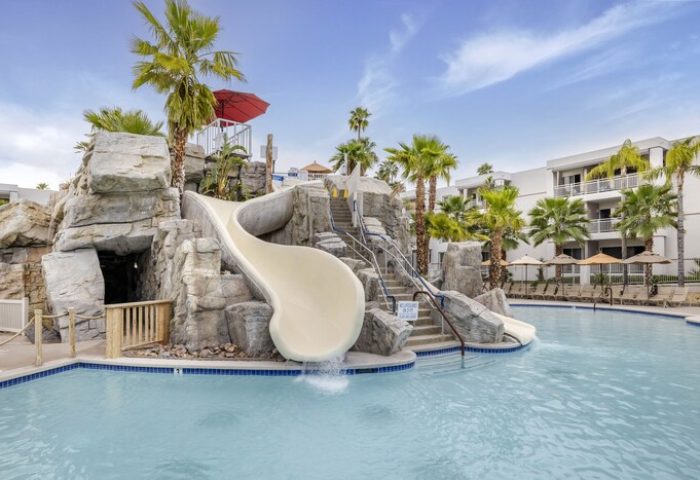 Palm Canyon Resort's pool with a waterslide. This gay-friendly hotel in Palm Springs features a fun water area for a relaxing vacation.