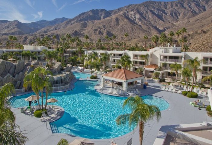 Hilton Vacation Club Palm Canyon Resort, a gay-friendly hotel in Palm Springs. Pool with mountain views, bar, and palm trees.
