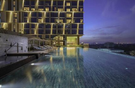 Pan Pacific Yangon gay-friendly hotel infinity pool at dusk. Upscale hotel for gay men travel in Yangon, Myanmar. Relaxing poolside view.