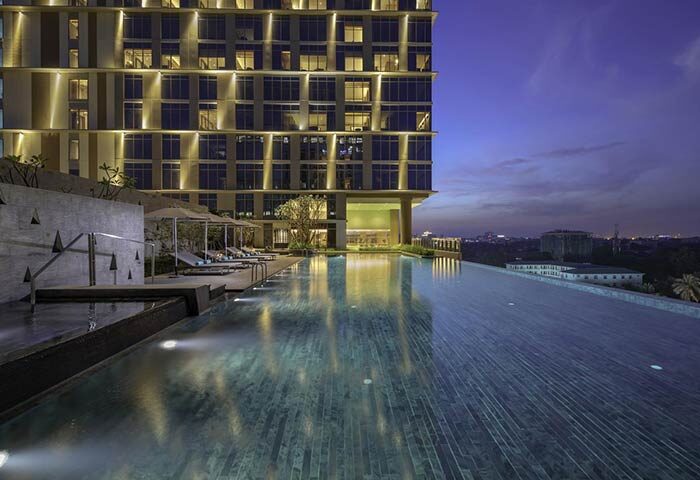 Pan Pacific Yangon gay-friendly hotel infinity pool at dusk. Upscale hotel for gay men travel in Yangon, Myanmar. Relaxing poolside view.