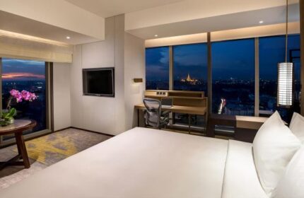 Pan Pacific Yangon gay-friendly hotel room at night. City view, desk, and bed create a luxurious experience for gay travelers.
