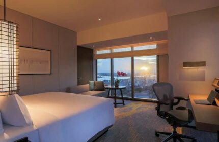 Pan Pacific Yangon gay-friendly hotel room with a bed, desk, and city view at sunset. A luxurious stay for gay travelers in Myanmar.