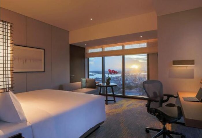 Pan Pacific Yangon gay-friendly hotel room with a bed, desk, and city view at sunset. A luxurious stay for gay travelers in Myanmar.
