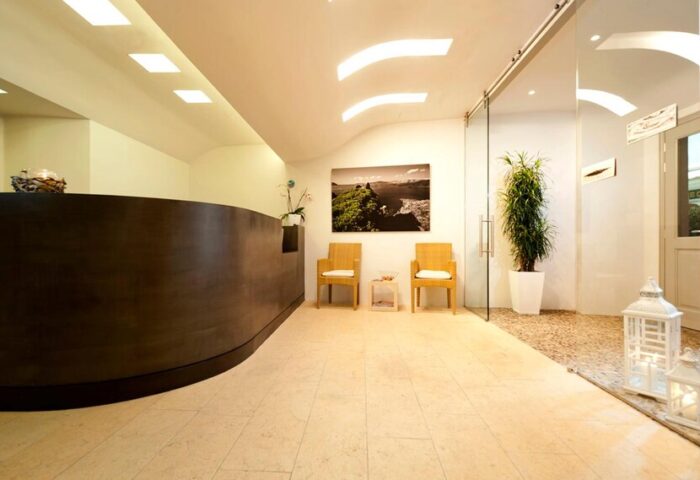 Panorama Boutique Hotel's lobby. Gay-friendly hotel with a modern reception area, seating, and a glass-enclosed space. Elegant design.