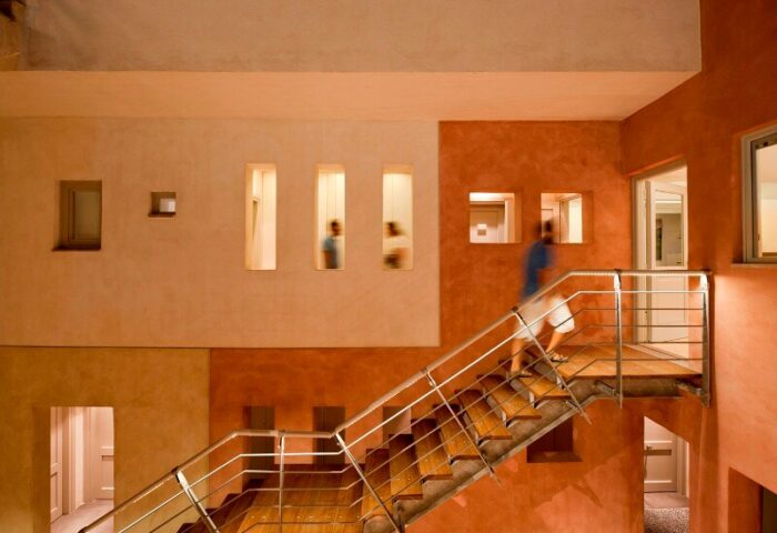 Panorama Boutique Hotel interior. Person on stairs in a gay-friendly hotel. Warm colors, modern design. Stylish travel lodging.