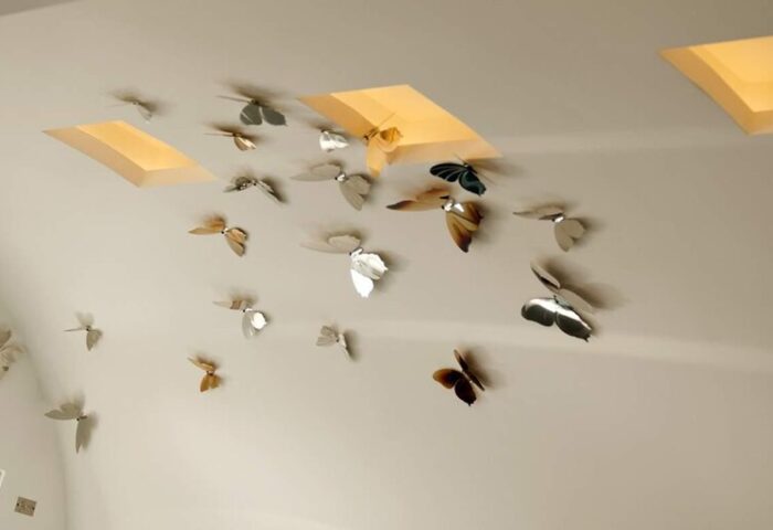 Panorama Boutique Hotel ceiling with butterfly art installation and skylights. Gay-friendly hotel design detail.