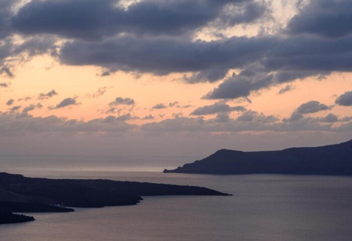 Sunset view from Panorama Boutique Hotel, a gay-friendly hotel. Dark islands silhouette against a colorful sky. Serene seascape.