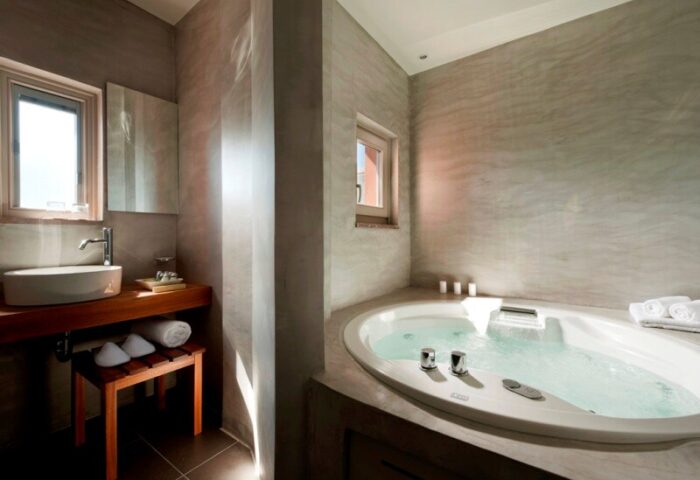 Bathroom at Panorama Boutique Hotel, a gay-friendly hotel. Features sink, jacuzzi tub, and modern design. Ideal for gay travel.