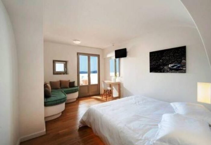 Panorama Boutique Hotel room. Gay-friendly hotel room with bed, couch, desk, and balcony. Modern, clean design for gay travelers.