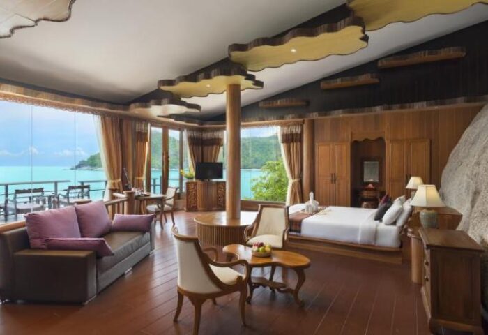Panviman Resort Koh Phangan suite. Gay-friendly hotel interior with sea view, sofa, bed, and unique design. A luxurious gay travel destination.
