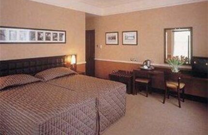Paramount Hotel room interior. Gay-friendly hotel with double bed, desk, chair, and warm lighting. Comfortable stay for gay men travelers.