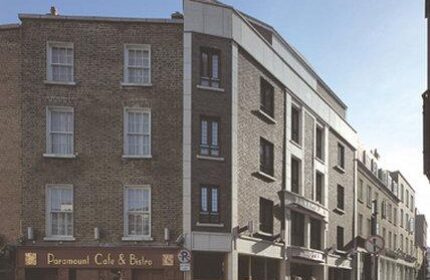 Exterior of the gay-friendly Paramount Hotel, a brick building with the Paramount Cafe & Bistro on the ground floor. A great choice for gay men travel.