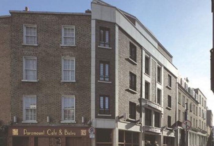 Exterior of the gay-friendly Paramount Hotel, a brick building with the Paramount Cafe & Bistro on the ground floor. A great choice for gay men travel.