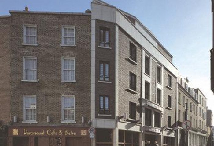 Exterior of the gay-friendly Paramount Hotel, a brick building with the Paramount Cafe & Bistro on the ground floor. A great choice for gay men travel.