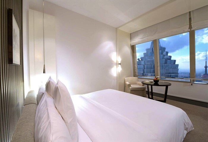 Gay-Friendly Hotel Park Hyatt Shanghai bedroom. View of Shanghai skyline, including Jin Mao Tower, from room's large window. Luxury travel.