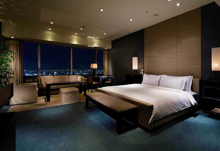 Park Hyatt Tokyo gay-friendly hotel bedroom. Pet-friendly, luxury suite with city view at night. Ideal for gay men travel to Tokyo.
