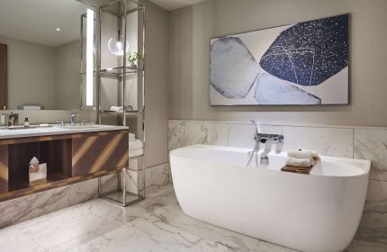Park Hyatt Toronto bathroom. Modern design with a white tub, marble floor, and abstract art. Gay-friendly hotel for gay men travel advice.