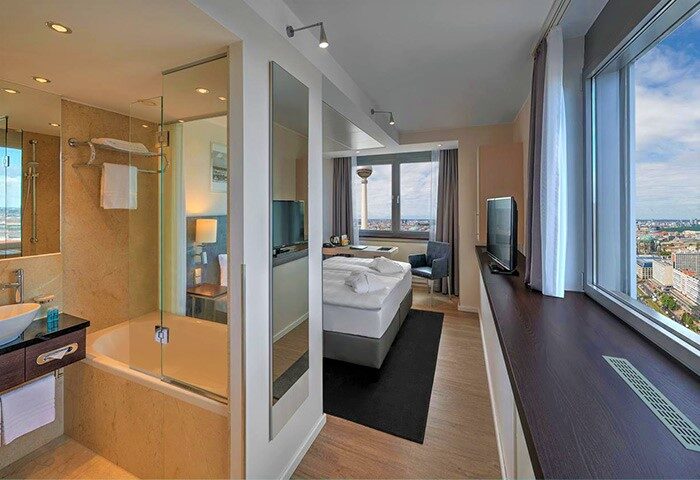 Park Inn by Radisson Berlin Alexanderplatz gay-friendly hotel room with city view, bathtub, bed and TV tower visible from the window.