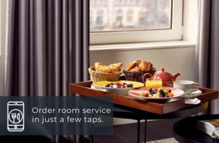 Room service at Park Plaza Victoria Amsterdam Hotel. Tray with croissants, fruit, juice, and tea. Gay-friendly hotel for gay men travel.