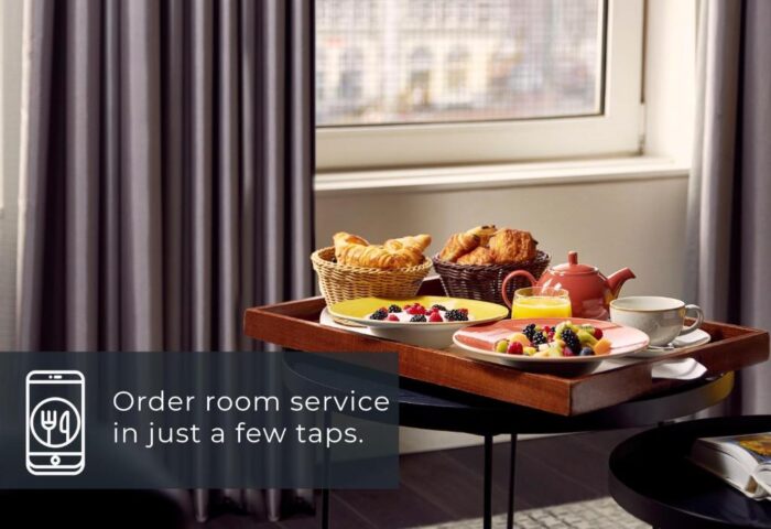 Room service at Park Plaza Victoria Amsterdam Hotel. Tray with croissants, fruit, juice, and tea. Gay-friendly hotel for gay men travel.