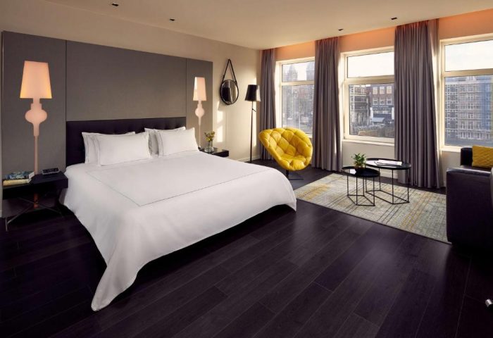 Park Plaza Victoria Amsterdam Hotel room. Modern design, city view, yellow chair. Gay-friendly hotel for gay men travel in Amsterdam.