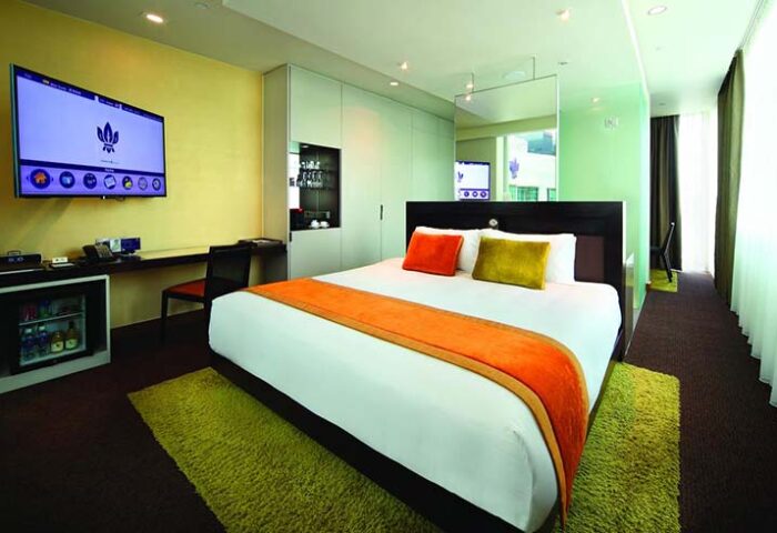 Park Regis Singapore gay-friendly hotel room. Modern design with a king-size bed, TV, desk, and mini-fridge. Comfortable stay for gay travelers.