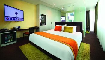Park Regis Singapore gay-friendly hotel room. Modern design with a king-size bed, TV, desk, and mini-fridge. Comfortable stay for gay travelers.
