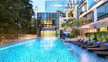 Park Regis Singapore gay-friendly hotel pool. Loungers line the pool's edge. Modern architecture and greenery create a relaxing urban oasis.