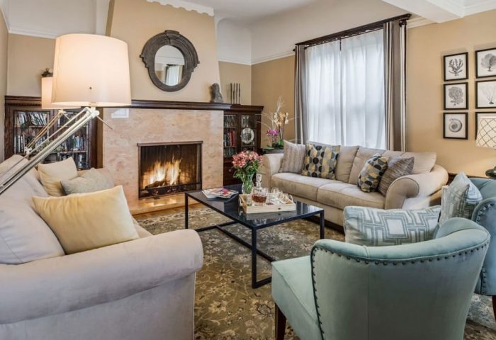 Cozy living room at Parker Guest House, a gay-friendly hotel. Fireplace, sofas, and chairs create a welcoming space for gay men travelers.