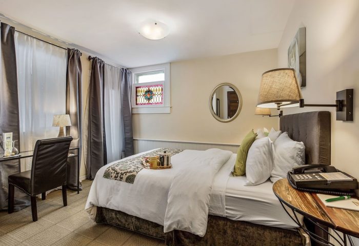 Parker Guest House room. Gay-friendly hotel room with bed, desk, chair, stained glass window, and modern decor. Gay travel lodging.
